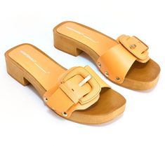 An absolute summer hit, these clog sandals feature an elegant wood-like base and large upper buckle for a statement style piece. From INTENTIONALLY BLANK. Summer Beach Clogs With Buckle Closure, Chic Clogs With Wooden Heel For Beach, Trendy Clogs With Buckle Closure, Chic Beach Clogs With Wooden Heel, Summer Mules With Tang Buckle And Round Toe, Chic Summer Slides With Tang Buckle, Trendy Beach Clogs With Wooden Heel, Chic Summer Mules With Tang Buckle, Chic Summer Clogs With Buckle Closure