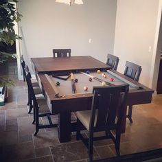 a pool table with chairs around it