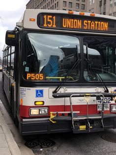 a bus parked on the side of the road in front of a building with an union station sign