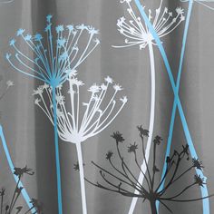 a shower curtain with dandelions and blue strips on the bottom, in front of a gray background