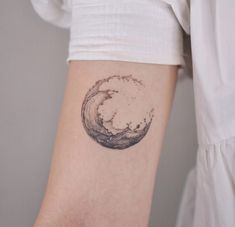 a woman's arm with a wave tattoo on it