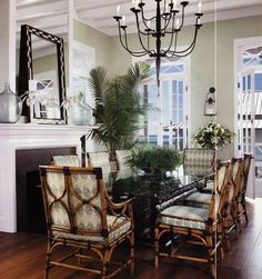 a dining room table with chairs and a chandelier hanging from the ceiling in front of a fireplace