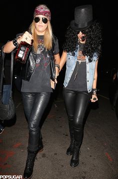 two women in leather pants and hats walking together