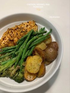 a white plate topped with chicken, potatoes and green beans