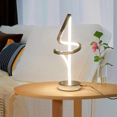 a table with a lamp on top of it next to a vase filled with flowers