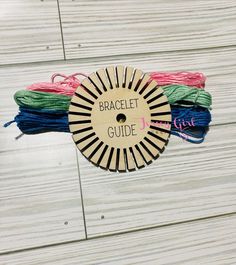 a bunch of different colored thread sitting on top of a wooden table next to each other