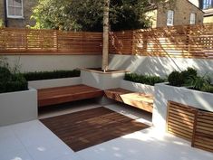 a wooden bench sitting on top of a white tiled floor next to a tall tree