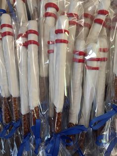 some white and red candy canes wrapped in plastic wrappers with blue ribbon around them