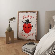 a ladybug poster sitting on the floor next to a bed