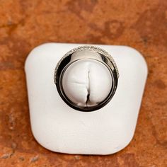 a wedding ring sitting on top of a piece of white paper in a display case