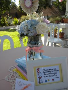 a vase filled with flowers sitting on top of a table next to a framed photo