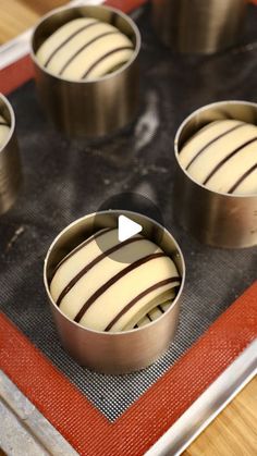 four metal pans filled with cake batter on top of a baking sheet in the shape of an apple