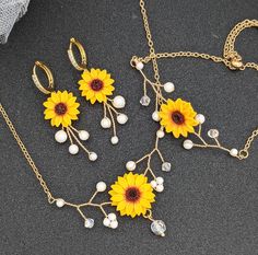 An elegant dainty sunflower necklace jewelry set accented with Swarovski Pearls and Crystals perfect for bride and bridesmaids. Details Necklace length measures 16 inches adjustable upto 22 inches approximately Bracelet measures 5.5 inches adjustable upto 8.5 inches approximately which fits most wrists. Earring measures 2 inches from the lobe approximately. Elegant Adjustable Sunflower Design Jewelry, Elegant Adjustable Sunflower Jewelry, Sunflower Design Jewelry For Mother's Day, Elegant Round Jewelry With Sunflower Design, Elegant Round Sunflower Design Jewelry, Elegant Round Sunflower Jewelry, Wedding Jewelry With Sunflower Design, Mother's Day Sunflower Design Jewelry, Yellow Round Sunflower Jewelry