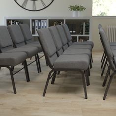 a bunch of chairs that are sitting in the middle of a room with a clock on the wall