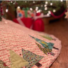 a close up of a quilted christmas tree ornament on a wooden floor