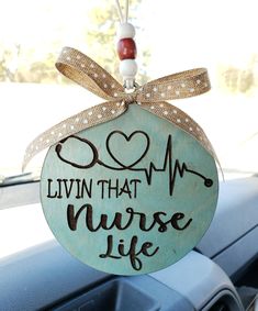 a wooden sign that says livvin that nurse life hanging from the dashboard of a car