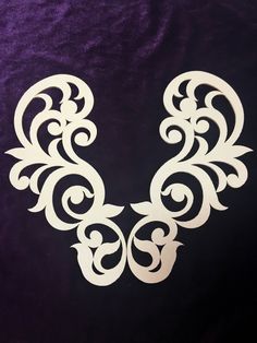 an intricate white design on a purple velvet background