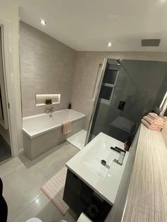 a bathroom with a tub, sink and shower in it's own area is shown