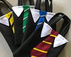 four harry potter inspired ties are in a black bag with white and yellow trims