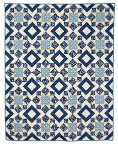 a blue and white quilt with diamond shapes on the front, in two different colors