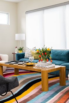 a living room filled with furniture and a colorful rug on top of a wooden table