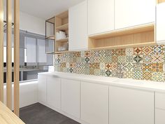 a kitchen with white cabinets and colorful tile backsplashes on the counter tops