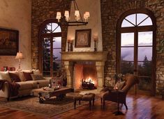 a living room filled with furniture and a fire place in front of two large windows