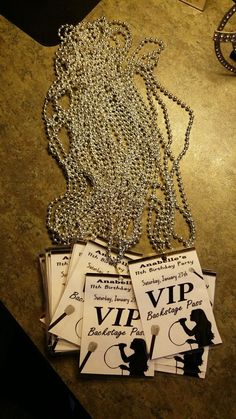 some cards are laying on a table next to a silver chain and an open book