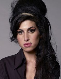 a woman with long black hair and makeup looks at the camera while posing for a photo