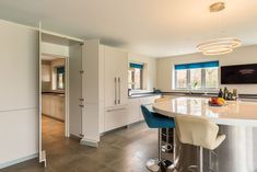 a kitchen with an island and bar stools next to the counter top in front of it