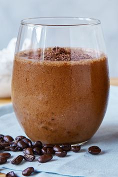 a glass filled with chocolate milk and coffee beans