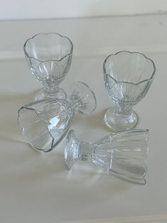 three clear glass vases sitting on top of a white countertop next to each other