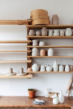 the shelves are filled with pottery and pots