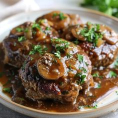 meatballs covered in mushrooms and gravy on a plate