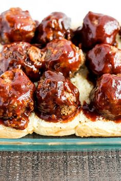 meatballs with sauce on top of bread in a glass dish