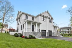 a large white house sitting on top of a lush green field