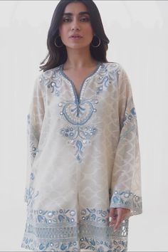 Bollywood Style Kurta With Embroidered Neckline For Eid, Bollywood Style Straight Kurta With Embroidered Neckline, White Kaftan With Mirror Work For Eid, Chanderi Kurta With Embroidered Neckline And Long Sleeves, Long Sleeve Chanderi Kurta With Embroidered Neckline, Festive Eid Top With Embroidered Neckline, Eid Chanderi Tunic With Resham Embroidery, Eid Tunic With Resham Embroidery In Chanderi, Chanderi Tunic With Resham Embroidery For Eid