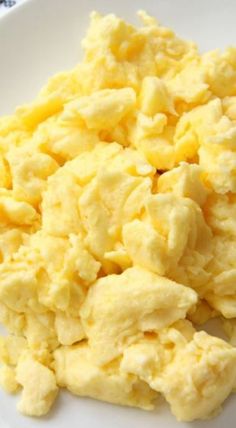 a white plate topped with scrambled eggs on top of a table