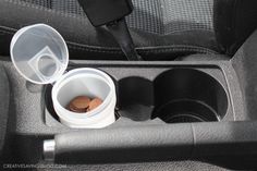 two plastic cups with coins in them sit inside the back seat of a car