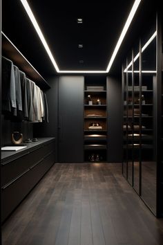 a walk in closet with wooden floors and black walls, lighted by recessed lighting