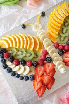 sliced fruit arranged on a cutting board with flowers in the background