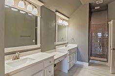 a large bathroom with two sinks and mirrors