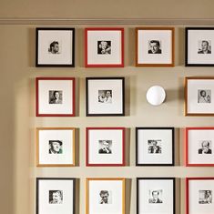 a wall with many framed pictures on it