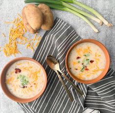 two bowls of soup with cheese and green onions