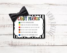 a candy prayer card with a black bow on the front and rainbows in the back