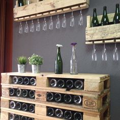 a wine rack made out of wooden pallets with bottles and glasses on the top