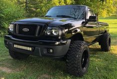 a black pickup truck parked in the grass