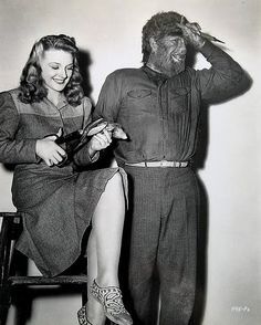 an old black and white photo of a woman sitting on a chair next to a man