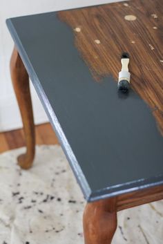 a black table with some paint on it and a brush sticking out of the top