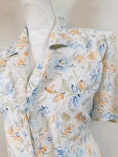 "Vintage 80s Pastel Beige Blue Floral Print Abstract Tie Back Collared Button Down Short Sleeve Shirt Top Blouse Large This item is used but in good condition. Has no rips, tears, staining, and hardly any wear and tear. No sz tag. Appropriate for any casual or evening occasion. Measurements: Bust: 46\" Waist: 46\" Hips: 46\" Overall Length: 26\" Domestic Customers: First Class Shipping International Customers: Calculated rate (varies by listing due to weight). Any flaws will be noted in item des Cheap Blue Floral Print Shirt, Affordable Blue Floral Print Shirt, Cheap Floral Print Collar Tops, Affordable Light Blue Floral Print Shirt, Short Sleeve Floral Grandma Ahirt, Cheap Collared Top With Vintage Print, Cheap Floral Print Button-up Shirt, Affordable Vintage Print Collared Top, Cheap Patterned Shirt With Vintage Print